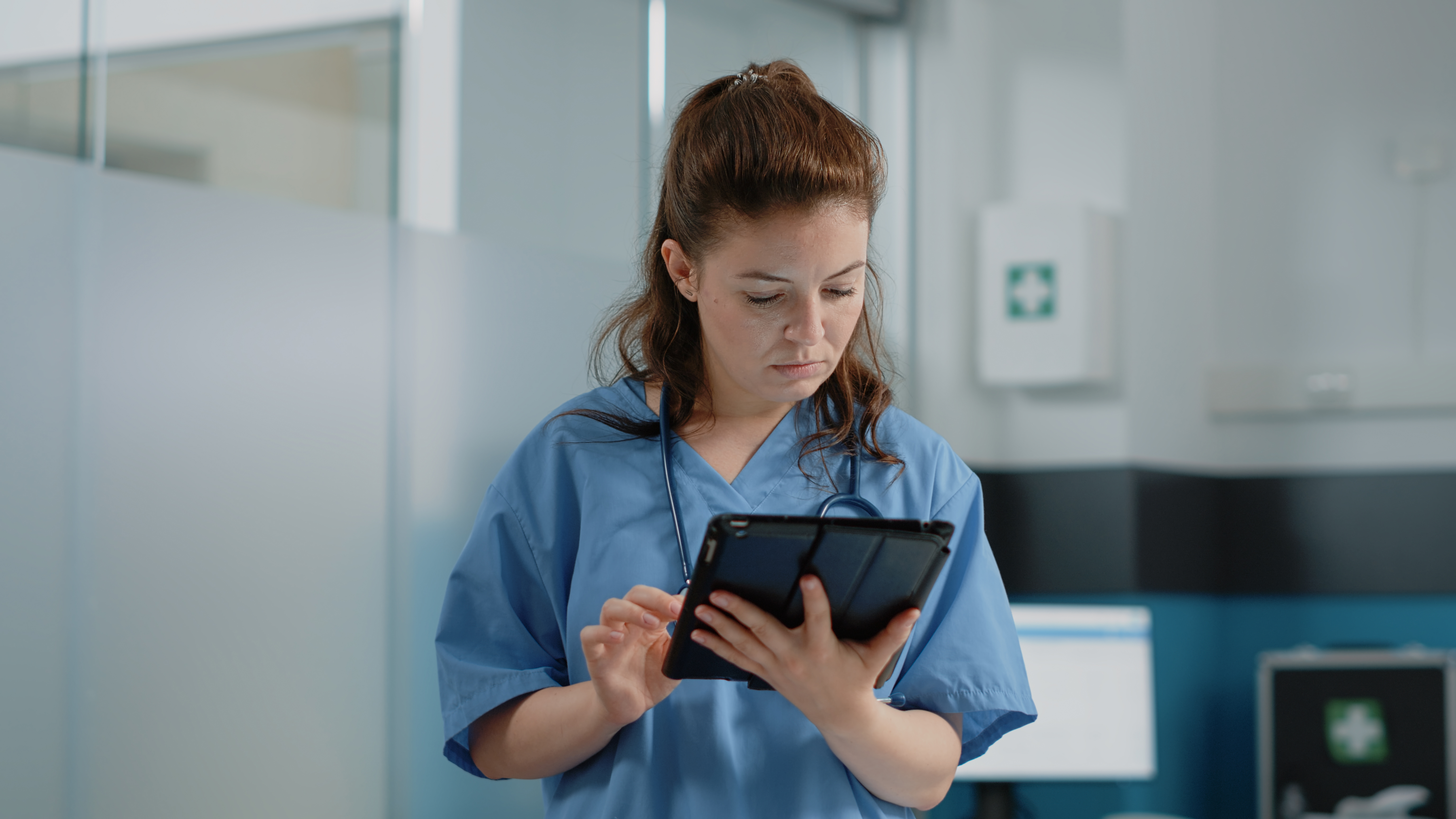Medical billing professional working with a tablet in a bright healthcare office
